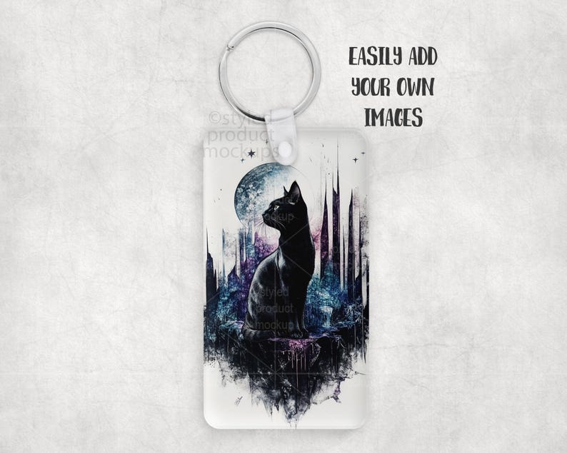 K&ouml;nnte beinhalten: Ein rechteckiger Schl&uuml;sselanh&auml;nger mit einem silbernen Ring. Der Schl&uuml;sselanh&auml;nger zeigt eine Illustration einer schwarzen Katze mit Vollmond und Stadtlandschaft im Hintergrund. Der Text "EASILY ADD YOUR OWN IMAGES" ist auf der rechten Seite aufgedruckt.