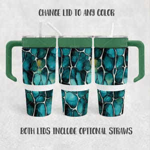 May include: Three tumblers with green handles and lids, featuring a teal and blue abstract pattern. The tumblers have white bases and include optional straws. The text "CHANGE LID TO ANY COLOR" and "BOTH LIDS INCLUDE OPTIONAL STRAWS" are visible.