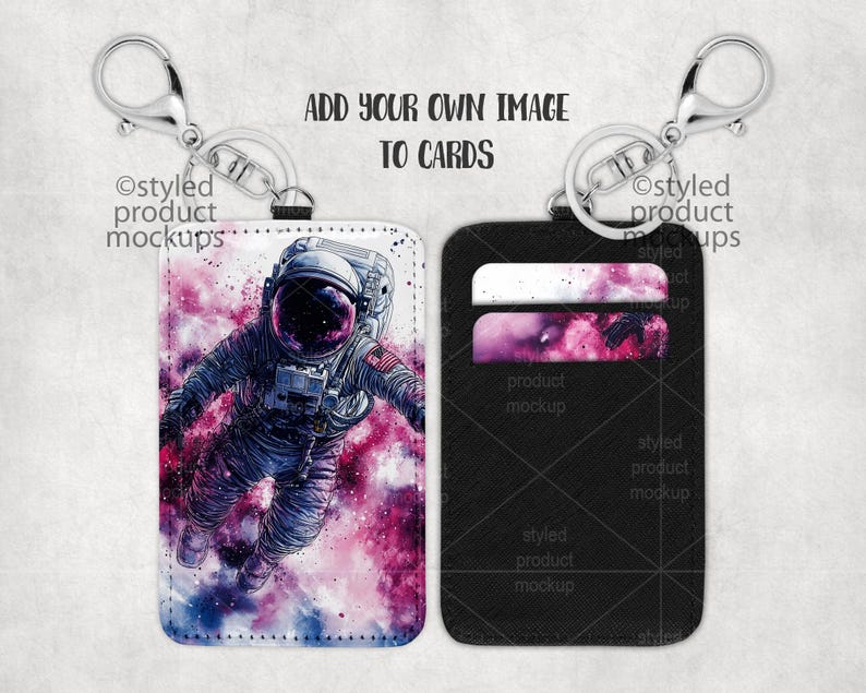 May include: Two keychains with card holders. One keychain has a white card holder with a colorful astronaut illustration. The other keychain has a black card holder with two card slots.