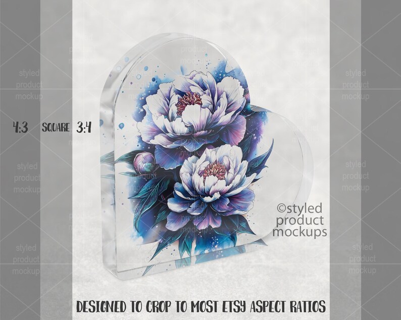 Pu&ograve; includere: Un blocco acrilico trasparente a forma di cuore con un motivo floreale ad acquerello. Presenta peonie bianche e viola e foglie blu. Il testo recita "DESIGNED TO CROP TO MOST ETSY ASPECT RATIOS".