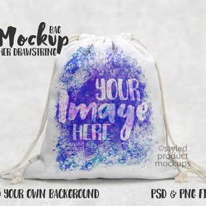 以下が含まれることがあります： 白い巾着袋のモックアップで、水彩画のデザインが施されています。青、紫、ピンクの色合いです。袋には「YOUR IMAGE HERE」という文字が書かれています。