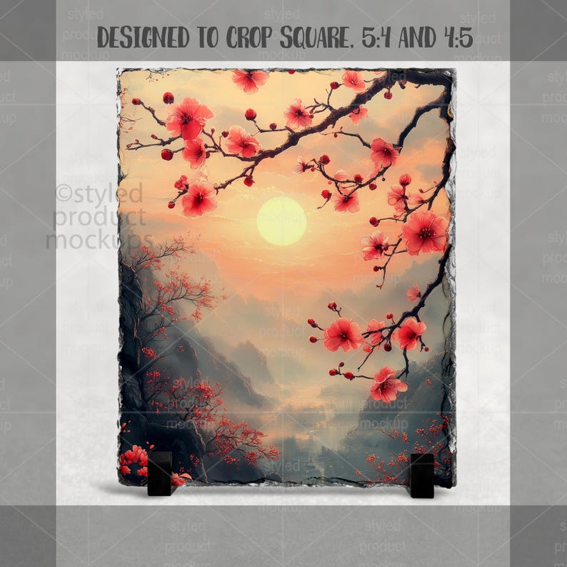 Puede incluir: Una pieza de arte rectangular de pizarra con un paisaje sereno con una puesta de sol, monta&ntilde;as y flores de cerezo. La obra de arte tiene un borde natural y texturizado y est&aacute; soportada por dos soportes negros. El texto "DESIGNED TO CROP SQUARE. 5:4 AND 4:5" est&aacute; en la parte superior.