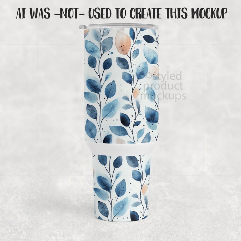 K&ouml;nnte beinhalten: Ein wei&szlig;er Becher mit einem botanischen Design aus blauen und pfirsichfarbenen Bl&auml;ttern und Stielen. Der Text "AI WAS -NOT- USED TO CREATE THIS MOCKUP" steht oben. Der Becher hat einen silbernen Deckel.