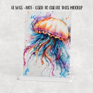Puede incluir: Una impresi&oacute;n de acuarela de una medusa en colores vibrantes, incluyendo naranja, rosa, azul y morado. La medusa se muestra en un soporte blanco, con el texto "AI WAS -NOT- USED TO CREATE THIS MOCKUP" en la parte superior.