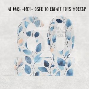 Op de afbeelding: Een decoratief nummer 60, met een bloemmotief van blauwe en perzikbladeren op een witte achtergrond. De transparante cijfers staan op een bijpassende basis. De tekst "AI WAS -NOT- USED TO CREATE THIS MOCKUP" staat bovenaan.