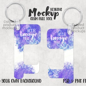 May include: A purple and white watercolor design key chain with a metal ring. The keychain has a hook on the bottom and the text "Your Image Here" is printed on the front. The text "Ostyled product mockups" is printed on the top left and right corners. The text "Mockup Keyring Germ Free Tool" is printed in black at the top of the image.