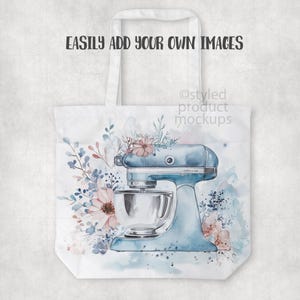Pu&ograve; includere: Borsa tote bianca con un'illustrazione di un robot da cucina azzurro chiaro e accenti floreali rosa e blu. Il testo "EASILY ADD YOUR OWN IMAGES" &egrave; stampato in alto. La borsa ha manici bianchi.