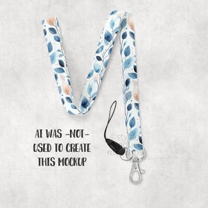 May include: A lanyard with a watercolor leaf pattern in shades of blue and peach. The lanyard has a black clasp and a silver-colored metal clip. The text "AI WAS -NOT- USED TO CREATE THIS MOCKUP" is printed on the background.