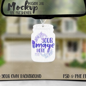 May include: A white mason jar air freshener mockup with a watercolor floral design and the text "Your Image Here". The mockup is hanging from a rearview mirror in a car. The background is blurred and shows a house.