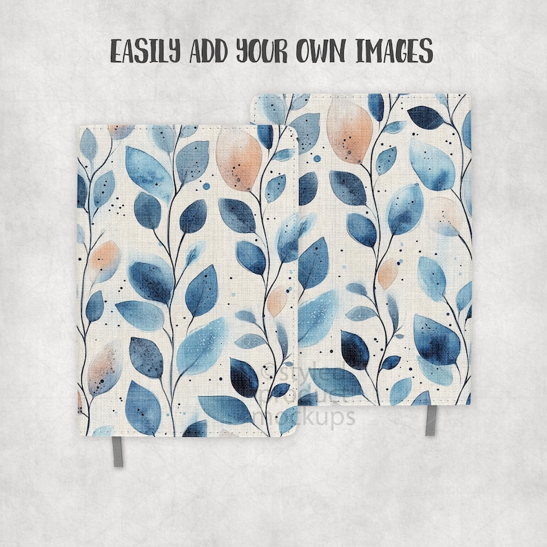 May include: Two notebooks with a watercolor design of blue leaves and peach-colored accents on a cream background. The notebooks have a fabric-like texture and a gray ribbon bookmark. The text "EASILY ADD YOUR OWN IMAGES" is at the top.
