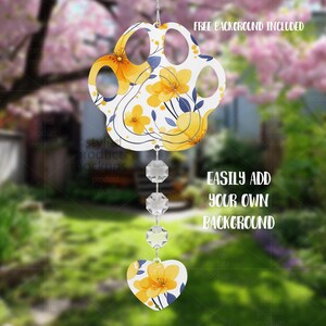 May include: A paw-shaped ornament with yellow floral designs and blue accents, suspended by a string of clear crystals. A heart-shaped charm with matching floral patterns hangs below. The text "FREE BACKGROUND INCLUDED" and "EASILY ADD YOUR OWN BACKGROUND" are visible.