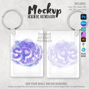 Op de afbeelding: Een mockup van twee acryl sleutelhangers met zilveren sleutelringen. De sleutelhangers hebben een witte achtergrond met een paars en blauw ontwerp en de letters "SPM". De tekst "Mockup Acrylic Keychain" staat bovenaan.