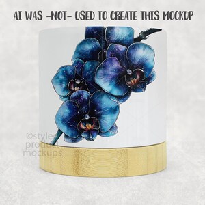 Op de afbeelding: Een witte keramische mok met een goudkleurige bamboe basis. De mok heeft een gedetailleerde illustratie van blauwe orchidee&euml;n met een galaxy-achtig patroon. De tekst "AI WAS -NOT- USED TO CREATE THIS MOCKUP" staat bovenaan.