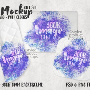 Peut inclure: Un ensemble de deux maniques blanches et un gant de cuisine blanc avec un motif aquarelle violet et bleu. Le motif présente un effet de projection avec les mots "Votre image ici" en texte blanc. Le texte "Mockup Gift Set Board + Pot Holders" est en texte noir en haut de l'image. Le texte "Ostyled product mockups" est en texte noir en bas de l'image.