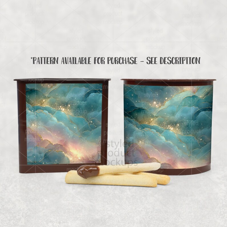 Op de afbeelding: Twee donkerbruine bakjes met een abstract wolkenpatroon in blauwgroen, blauw en goud met glinsterende accenten. De tekst "PATTERN AVAILABLE FOR PURCHASE - SEE DESCRIPTION" staat erboven. Drie lichte koekjesstengels liggen op de voorgrond.