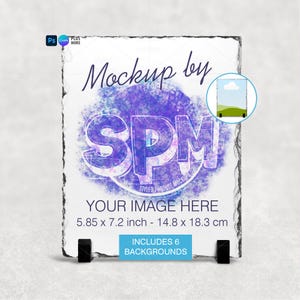 Puede incluir: Maqueta de producto de pizarra rectangular con borde rugoso, sostenida por dos soportes negros. El dise&ntilde;o presenta el texto "Mockup by SPM" sobre un fondo de acuarela morado y azul. Dimensiones: 14,8 x 18,3 cm.