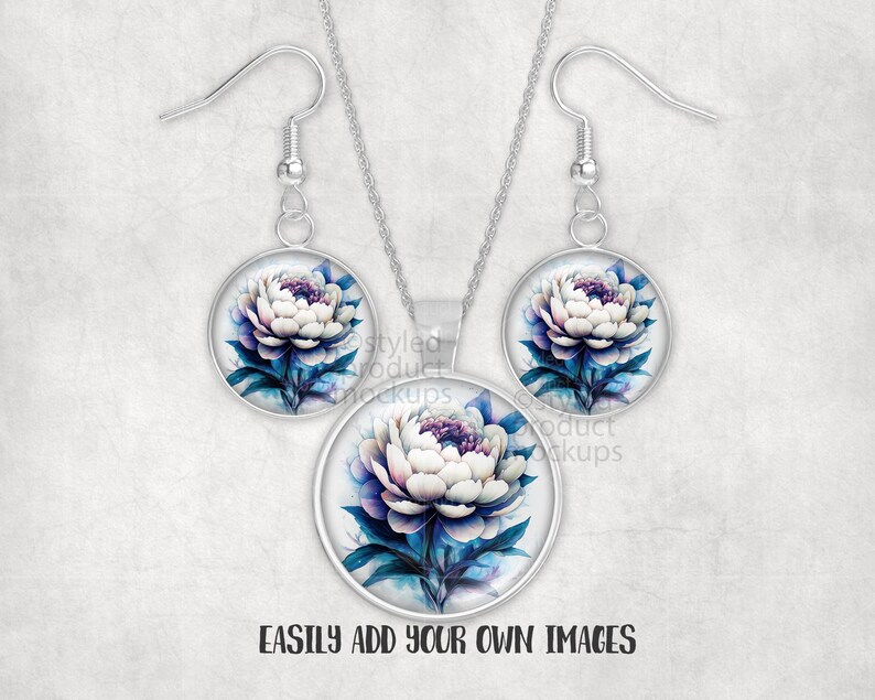 May include: A jewellery set with a floral design. The set includes a necklace pendant and a pair of earrings. Each piece has a round, silver-toned frame with a watercolour-style image of a white and purple peony flower with blue leaves.
