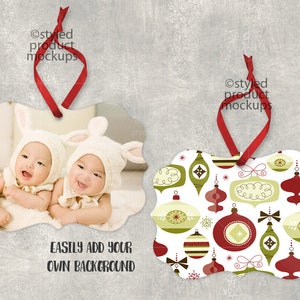 May include: Two baby ornaments with a photo of twins wearing bunny ears and white hats. The ornaments are white with a scalloped edge and a red ribbon for hanging. The text "EASILY ADD YOUR OWN BACKGROUND" is printed below the ornaments.