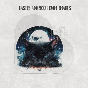 May include: A clear, heart-shaped acrylic block featuring a black cat with blue eyes against a backdrop of a full moon and starry night sky. The text "EASILY ADD YOUR OWN IMAGES" is at the top.