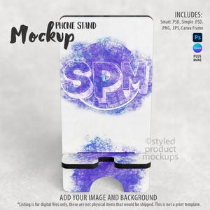 May include: A white phone stand mockup with a purple and blue abstract design. The stand features the letters "SPM" in a stylized font. Text on the stand includes "PHONE STAND", "Mockup", and "ADD YOUR IMAGE AND BACKGROUND".