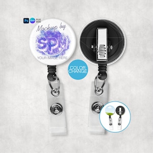 May include: Two white retractable badge holders with a round design. One badge holder has a purple and white design with the text "SPM" and "YOUR IMAGE HERE". The other badge holder is black. A small circle shows color change options.