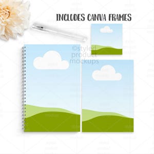 Op de afbeelding: Een product-mockup met een spiraalgebonden notitieboek, twee rechthoekige frames en een pen. Het notitieboek en de frames hebben een hemelsblauwe achtergrond met witte wolken en groene heuvels. De tekst "INCLUDES CANVA FRAMES" staat bovenaan.