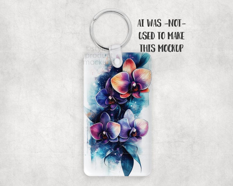 K&ouml;nnte beinhalten: Rechteckiger Schl&uuml;sselanh&auml;nger mit einem Aquarelldesign aus lila, orangefarbenen und blauen Orchideen. Der Schl&uuml;sselanh&auml;nger hat einen silberfarbenen Ring und einen transparenten Kunststoffaufsatz. Der Text auf dem Bild lautet: AI WAS -NOT- USED TO MAKE THIS MOCKUP.