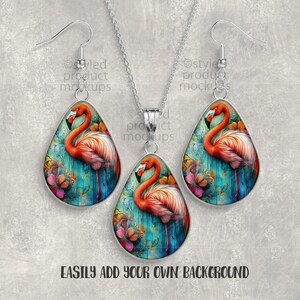 May include: A jewelry set featuring a flamingo design. The set includes a necklace and a pair of earrings. Each piece has a teardrop shape with a silver-colored border. The flamingo is depicted with pink and orange feathers against a teal and floral background.
