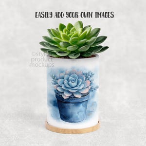 May include: A cylindrical white planter with a watercolor design of a blue succulent in a blue pot. The planter sits on a round, light brown wooden base. A live green succulent plant sits atop the planter. Text at the top reads: EASILY ADD YOUR OWN IMAGES.