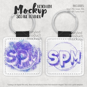 May include: Two white square leather keychains with silver rings. The keychain on the left has a purple and blue watercolor design with the letters "SPM" in the center. The keychain on the right has a black and white line drawing of the letters "SPM" in the center. Both keychains have the text "Styled Product Mockups" below the letters.