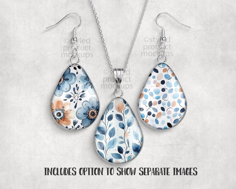 May include: A silver-toned jewelry set featuring a teardrop pendant necklace and matching earrings. The pendants and earrings have a floral design with blue, orange, and white watercolor flowers and leaves. The text "INCLUDES OPTION TO SHOW SEPARATE IMAGES" is at the bottom.