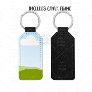 以下が含まれることがあります： 風景デザインと無地の黒のデザインのキーホルダー。風景キーホルダーは、白い雲と緑の丘のある青い空が特徴です。「INCLUDES CANVA FRAME」というテキストが上部にあります。