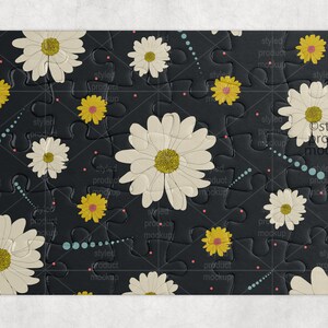 May include: A black jigsaw puzzle with a white daisy pattern. The puzzle pieces are arranged in a grid pattern and have a textured surface. The text "Styled Product Mockups" is printed in white on the puzzle.