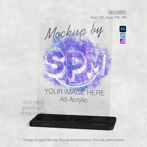 Puede incluir: Una maqueta acr&iacute;lica A5 transparente con una base negra, que muestra el texto "Mockup by SPM" y "Your Image Here". La imagen incluye iconos de software de dise&ntilde;o y el texto "Includes: Smart .PSD, Simple .PSD, .PNG."