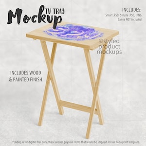 May include: A wooden TV tray mockup with a light wood finish. The tray is folded and has a light blue and purple watercolor design on the top. The text "TV TRAY Mockup" is at the top of the image. The text "INCLUDES: Smart PSD, Simple PSD, .PNG Canva NOT included" is at the top right of the image. The text "INCLUDES WOOD & PAINTED FINISH" is at the bottom left of the image. The text "Ostyled product mockups" is at the bottom right of the image.
