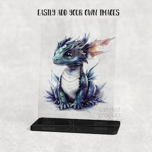 Puede incluir: Ilustraci&oacute;n en acuarela de un beb&eacute; drag&oacute;n con escamas azules y verdes, sentado sobre un lecho de cristales morados y azules. El drag&oacute;n tiene ojos grandes y expresivos y peque&ntilde;as alas con detalles en naranja. El texto "EASILY ADD YOUR OWN IMAGES" est&aacute; arriba.