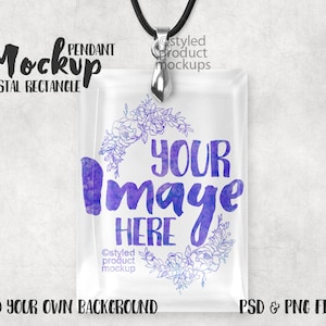 Puede incluir: Una maqueta de un colgante de cristal rectangular transparente con una anilla de plata y un cordón negro. El colgante tiene un diseño floral de acuarela con el texto "YOUR Image HERE" en morado y azul.