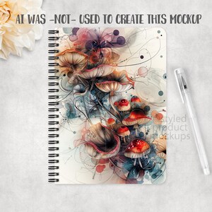 May include: Spiral-bound notebook featuring a whimsical mushroom design in shades of red, brown, and cream. The cover includes the text "AI WAS -NOT- USED TO CREATE THIS MOCKUP". A clear pen rests beside the notebook.