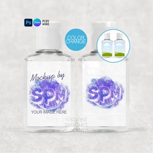 May include: Two clear plastic hand sanitizer bottles with white caps. Each bottle has a white label with the text "Mockup by SPM YOUR IMAGE HERE" in a purple design. The image also includes the text "COLOR CHANGE".