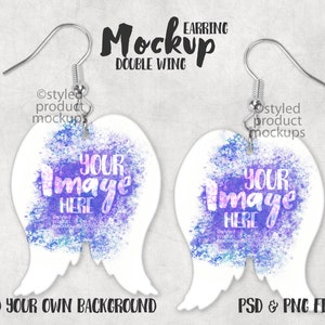 May include: Earring mockup featuring two white double-wing shaped earrings with silver hooks. Each earring has a purple and blue watercolor design with the text "YOUR IMAGE HERE". The image also includes the text "Mockup", "EARRING", "DOUBLE WING", "ADD YOUR OWN BACKGROUND", and "PSD & PNG FILES".
