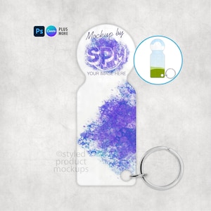 Puede incluir: Un llavero blanco con un diseño de acuarela púrpura. El llavero tiene un llavero plateado y una parte superior circular con el texto "Mockup by SPM YOUR IMAGE HERE". La imagen también incluye un pequeño gráfico de un llavero.