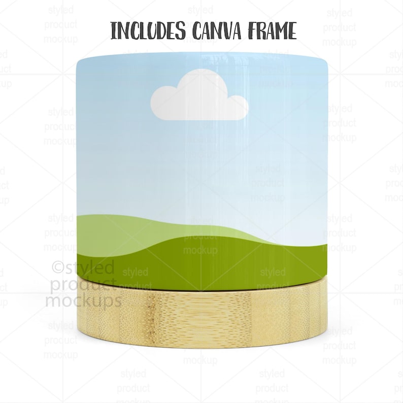 Op de afbeelding: Een cilindrisch productmodel met een landschapsontwerp met een blauwe lucht, witte wolk en groene heuvels. De basis is gemaakt van lichtgekleurd hout. De tekst bovenaan luidt "INCLUDES CANVA FRAME".