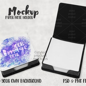 Könnte beinhalten: Ein weißer Papier-Notizblockhalter mit schwarzem Sockel. Der Halter hat ein blaues und violettes Aquarelldesign mit dem Text "YOUR Image HERE". Der Halter ist geöffnet und die Papiernotizen sind sichtbar. Der Halter befindet sich auf einem weißen Hintergrund.