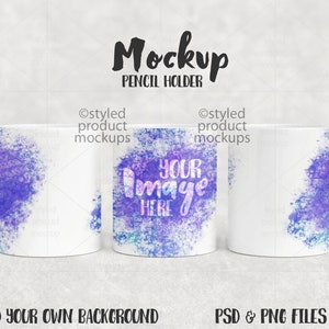 Puede incluir: Maqueta de tres porta lápices blancos con un diseño de estilo acuarela en tonos de morado y azul. El texto "Your Image Here" está en el porta lápices del medio.