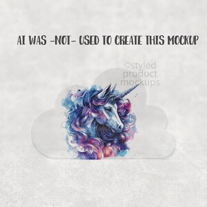 May include: A watercolor illustration of a unicorn with a blue and purple mane and a silver horn. The unicorn is set against a cloud-shaped background. Text at the top reads "AI WAS -NOT- USED TO CREATE THIS MOCKUP".