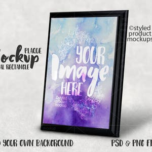 May include: A black framed vertical rectangle plaque mockup with a watercolor background featuring purple, pink, and blue hues. The text "Your Image Here" is written in white on the watercolor background.