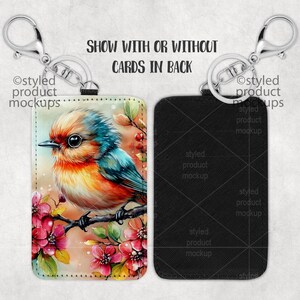 May include: A keychain with a black leatherette card holder featuring a colorful bird illustration with pink flowers. The text "SHOW WITH OR WITHOUT CARDS IN BACK" is printed on the image.
