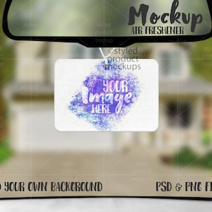 Puede incluir: Maqueta de un ambientador de coche colgado de un espejo retrovisor. El ambientador es blanco con un diseño de acuarela de salpicaduras de pintura púrpura y azul. El texto "Your Image Here" está escrito en negro en el ambientador.
