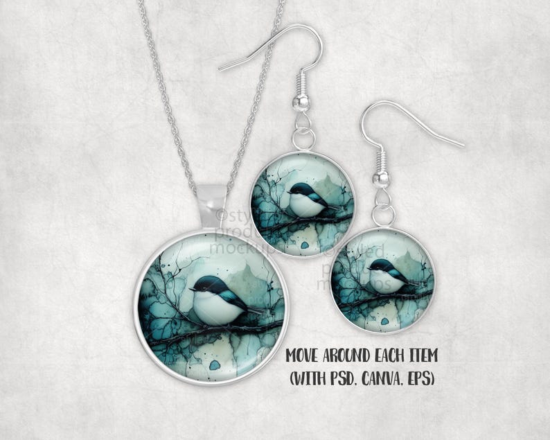 May include: A silver-toned jewellery set comprising a pendant necklace and drop earrings. Each piece features a circular setting with a watercolour illustration of a small bird on a branch. The bird has a white body and a dark blue head.