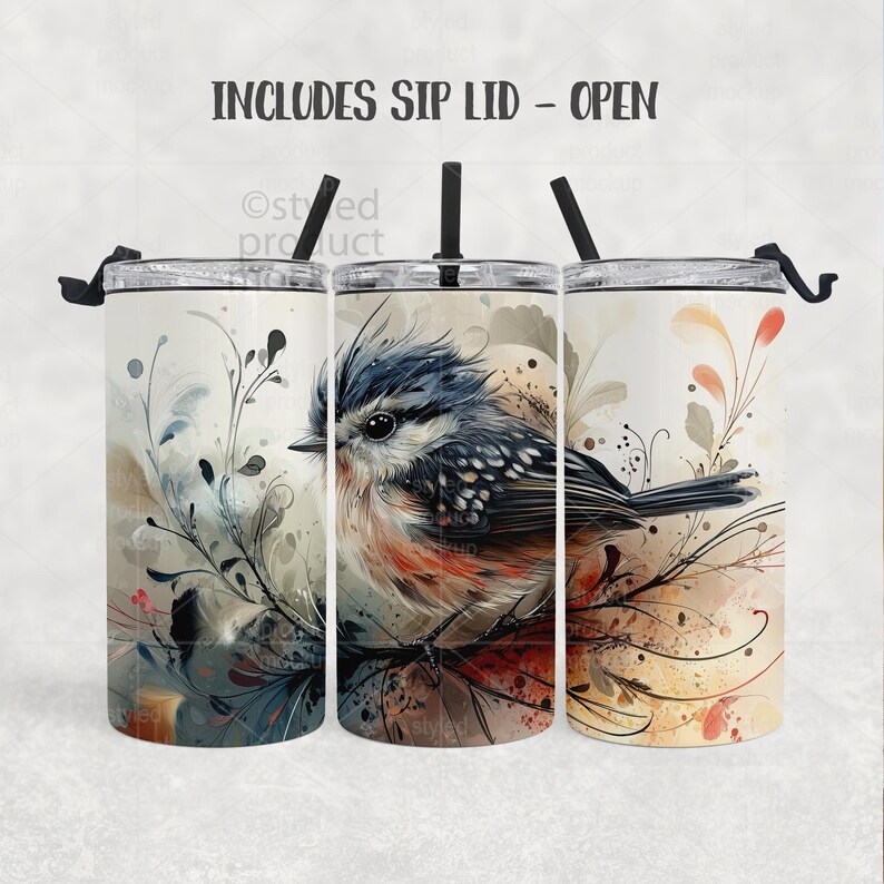 May include: Three stainless steel tumblers with a bird design. The bird is depicted with blue, orange, and brown feathers, perched on a branch with floral accents. Each tumbler includes a sip lid and a black straw. The text "INCLUDES SIP LID - OPEN" is at the top.